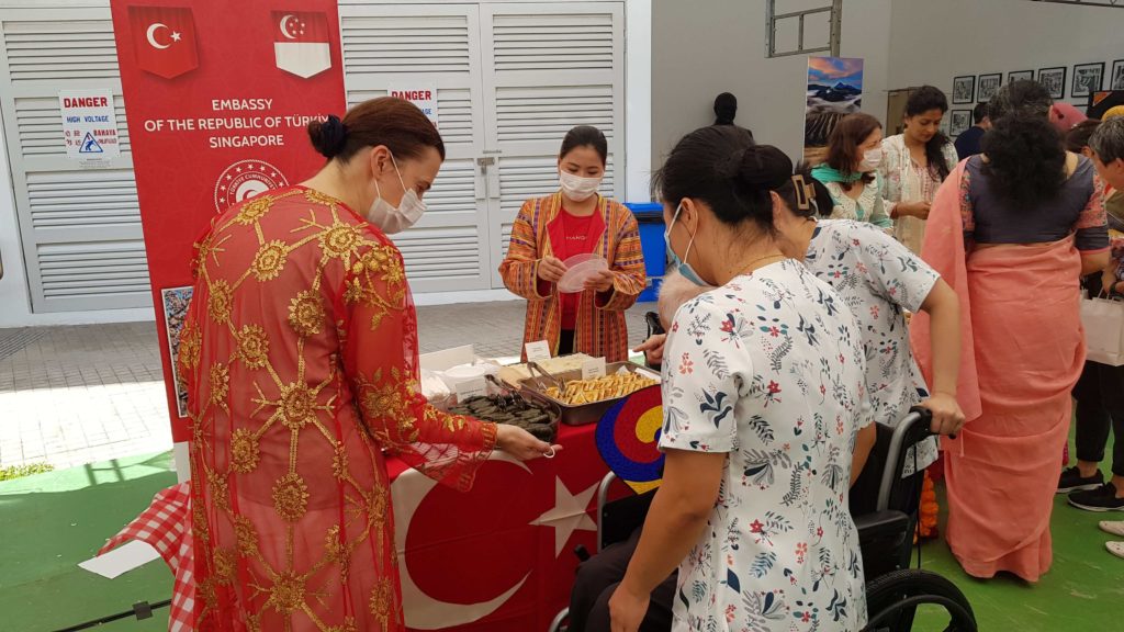 Three women surrounding the embassy of the Republic of Turkey to Singapore booth