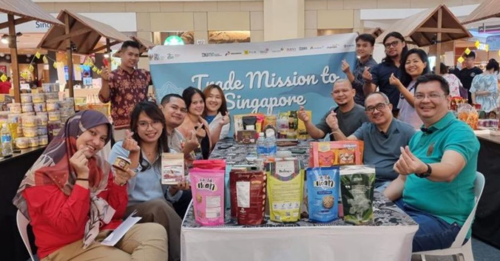 Indonesian Ambassador to Singapore, Suryo Pratomo, with participants of KADIN Trade Mission exibition posing to the camera while surrounded by SME food products 